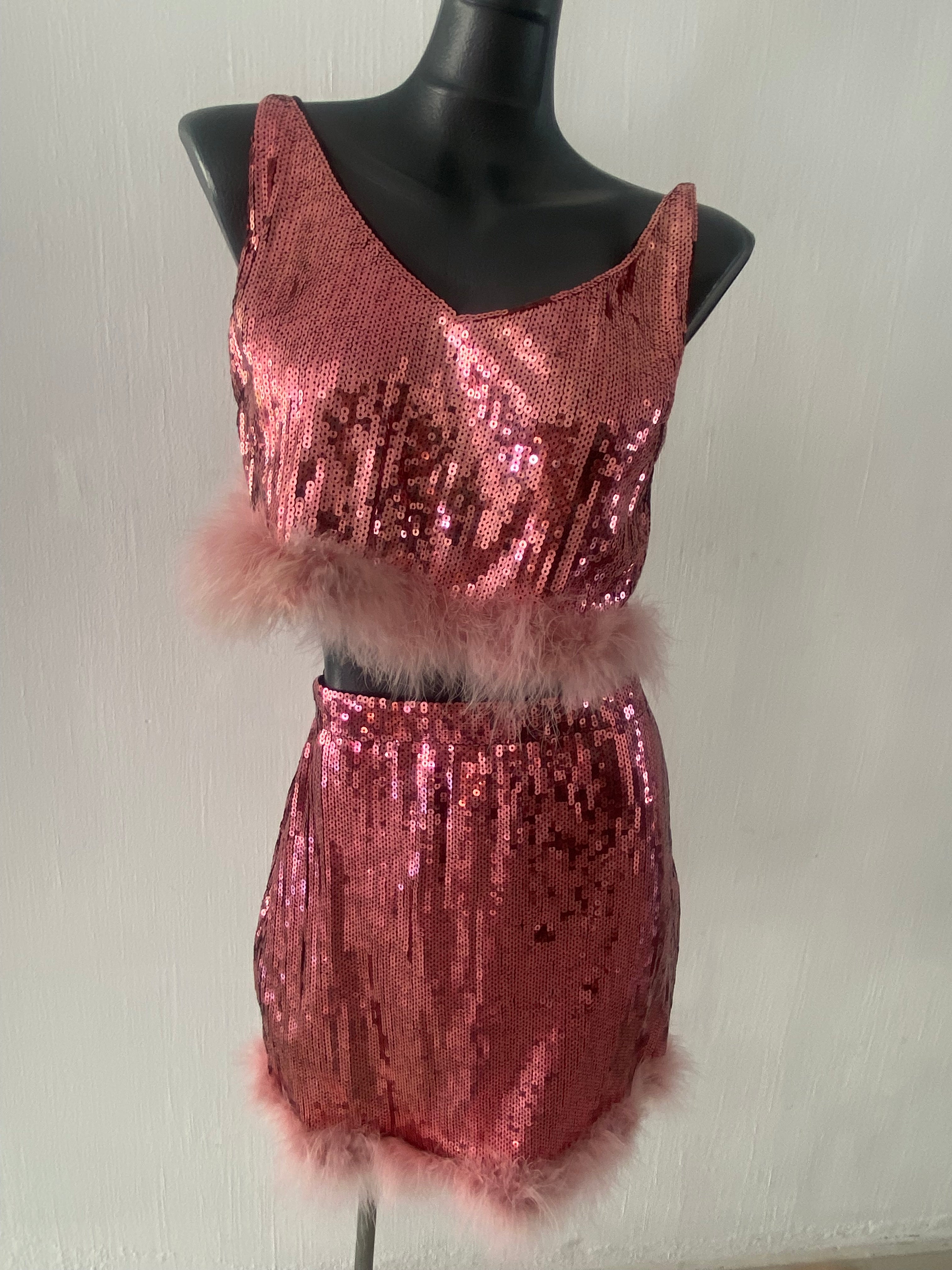 Conjunto juvenil se 2 piezas con tela de lentejuela en color rosa con adornos en plumas...