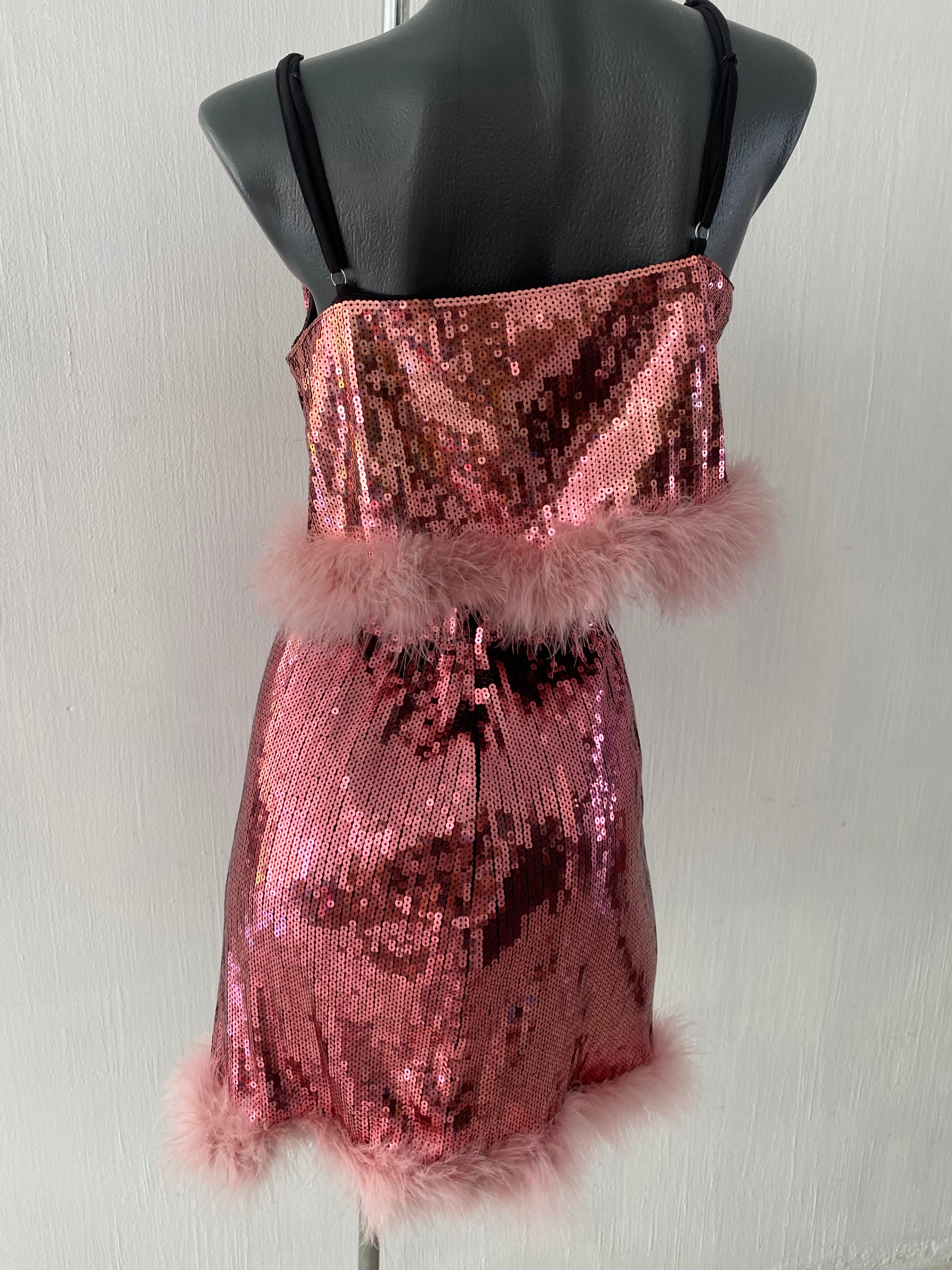 Conjunto juvenil se 2 piezas con tela de lentejuela en color rosa con adornos en plumas...