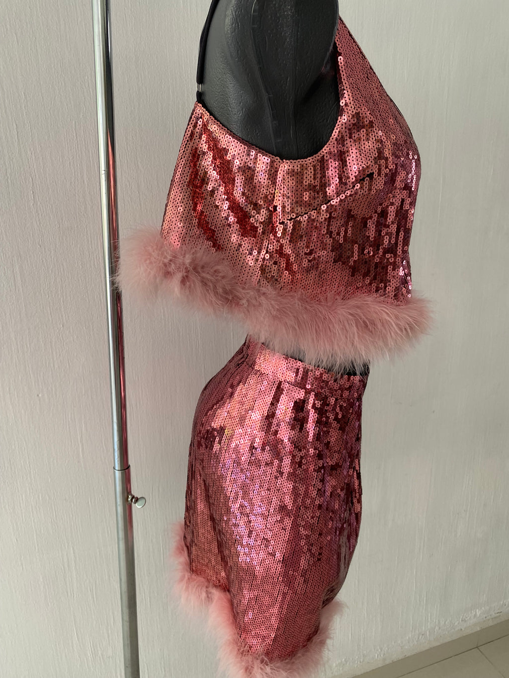 Conjunto juvenil se 2 piezas con tela de lentejuela en color rosa con adornos en plumas...